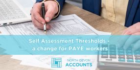 Person completing tax paperwork at a desk, illustrating Self Assessment thresholds changing for PAYE workers with guidance from North Devon Accounts